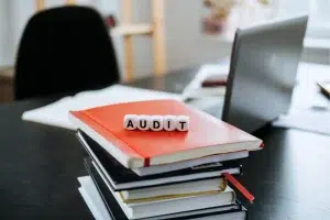 bureau avec classeur rouge et le mot audit