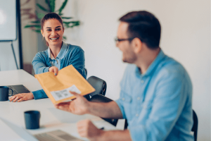 2 personnes échangeant un dossier d'entreprise